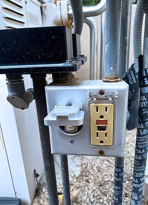 Weatherproof GFCI outlet mounted beside pool pump equipment